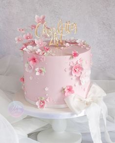 a pink cake decorated with flowers and the word congratulations on top