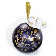 a harry potter christmas ornament hanging from a gold ribbon on top of it