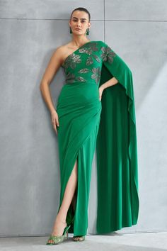 Forest green one shoulder gown with stone embellishment in floral placement pattern.
Components: 1
Pattern: Embellished
Type Of Work: Stone
Neckline: Asymmetric
Sleeve Type: One shoulder sleeve
Fabric: Jersey
Color: Green
Other Details: 
Front slit
Occasion: Cocktail - Aza Fashions Placement Pattern, Flowy Dress Long, Green Jersey, Gown For Women, Gown Pattern, Green Gown, One Shoulder Gown, Embellished Gown, Ladies Gown