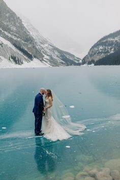 a bride and groom standing in the water