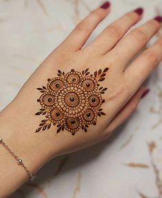 a woman's hand with a henna tattoo on it