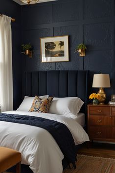 a bedroom with dark blue walls and white bedding is pictured in this image from the front