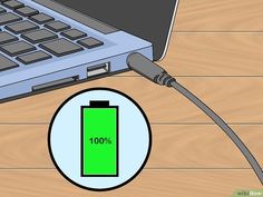 an electric charger plugged in to a laptop on a wooden table with a green battery