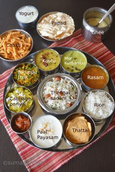 a metal plate topped with lots of different types of food on top of a table