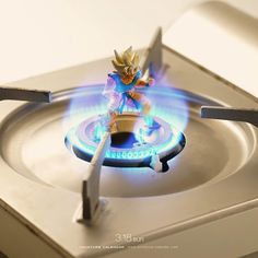 a toy figurine sitting on top of a gas stove with blue flames coming from it