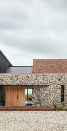 an exterior view of a modern house with stone walls