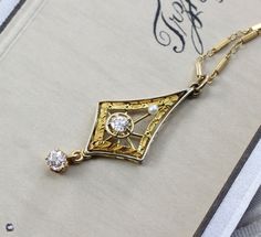 "Circa 1915, an elegant Edwardian lavaliere crafted in 14k yellow and white gold. The delicacy of the design is a perfect counterpoint to the blazing bright old mine-cut diamond set in the center, approximately .15 ct., accented by a single creamy pearl and finished with a fiery old mine-cut diamond drop, approximately .18 ct. It would be a wonderful piece for the bride who wants a romantic antique vibe; combining the gemlore of pearls and their symbolic reference to faithfulness and purity of h Art Deco White Gold Necklace With Rose Cut Diamonds, Victorian White Gold Necklace For Anniversary, White Gold Victorian Necklace For Anniversary, Victorian Style White Gold Necklace For Anniversary, Heirloom Diamond Necklace With Intricate Design, Heirloom Pendant Necklace For Formal Occasions, Antique Rose Cut Diamond Wedding Necklaces, Art Deco Diamond Necklace In Yellow Gold, Antique Diamond Cut Necklaces For Weddings