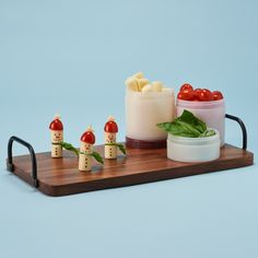 a wooden tray topped with food on top of a table