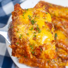 a close up of a plate of food with cheese and sauce on it, next to a fork