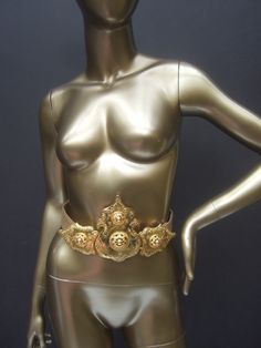 "Incredible massive gilt metal Etruscan couture belt by Alexis Kirk The exquisite huge scale shiny gilt metal hinged buckle makes a dramatic, show-stopping accessory The massive ornate gilt metal buckle is embellished with scrolled & impressed designs. The huge scale gilt metal buckle is designed in three individual sections Paired with a beige leather belt that crosses over a myriad of waist sizes. The backside of the large buckle is stamped: Alexis Kirk Measurements The center buckle heigh Elegant Gold Belt For Party, Luxury Gold Belt For Party, Elegant Gold Belt Buckles For Formal Wear, Elegant Gold Belt Buckles For Formal Occasions, Elegant Gold Belt Buckles For Party, Vintage Belt Buckles For Party, Vintage Belt Buckles With Removable Belt For Parties, Gold Belt With Antique Buckle For Formal Occasions, Elegant Gold Belt Buckles For Evening