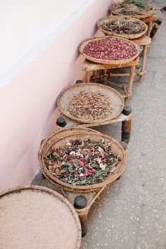 baskets with dried flowers are lined up against a wall