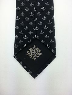 "Perfect for a black tie wedding. This black tie with Fleur De Lis design is a classic must have tie. Available as a extra long neck tie. Handmade from 100% silk, this special collection features a .75\" Eds Neckties logo at the bottom right front corner of every tie and a larger logo located on the tipping (Back of the tie). The label features the collection name (Nathaniel Alexandria) Named after my son Nathaniel and my daughter Alexandria. Expertly hand-made from 100% silk you can select your Silver Ties For Black Tie Events, Fitted Tuxedo With Ties For Black-tie Events, Luxury Fitted Ties For Wedding, Silver Standard Tie For Black Tie Events, Classic Silver Tie For Groom, Elegant Black Standard Tie And Suit Accessories, Classic Fitted Silver Suit And Tie Accessories, Classic Black Wedding Suit And Tie Accessories, Classic Black Suit And Tie Accessories For Wedding