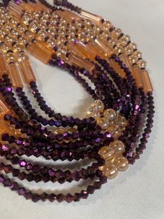 Why You'll Love It: Striking Design: The rich purple crystal glass beads paired with the warm golden sandy brown accents create a luxurious and timeless aesthetic. Premium Quality: Crafted with high-quality glass beads, ensuring durability and lasting brilliance. Comfortable Fit: The elastic design offers a comfortable and flexible fit for all-day wear. Versatile Style: Perfect for everyday wear, special occasions, or as a thoughtful gift. Cultural Significance: Purple: In Ivorian culture, purpl Brown Faceted Beads Jewelry For Party, Brown Beaded Necklaces With Round Beads For Party, Brown Beaded Bracelets With Round Beads For Party, Brown Faceted Beads Necklace For Party, Brown Gold Beads Jewelry For Party, Elegant Orange Beaded Necklaces With Spacer Beads, Elegant Orange Beaded Necklace With Spacer Beads, Elegant Brown Beaded Necklace For Party, Adjustable Brown Beads For Party