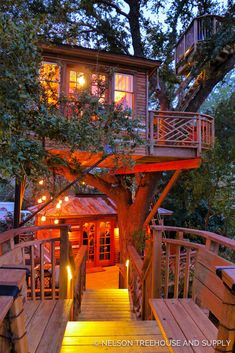 a tree house with stairs leading up to it and lit candles on the steps below