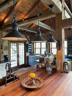 a kitchen with wood flooring and two pendant lights hanging from the ceiling over an island