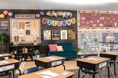 a classroom with desks, chairs and bulletin boards on the wall above them is decorated with colorful paper decorations