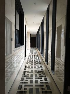 an empty hallway with black and white tiles on the floor