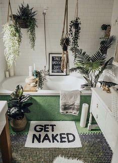 a bathroom with green tile and potted plants