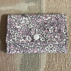 an apple button on a pink and white flowered case