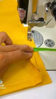 someone is using a sewing machine to sew something on yellow paper that has been stitched onto it