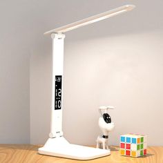 a lamp that is sitting on top of a table next to a clock and cubes