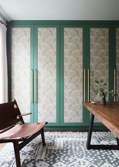 a wooden bench sitting in front of a green cabinet