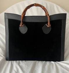 Beautiful Gucci Bamboo Maxi XL tote bag in black suede and leather. Double distinctive Bamboo handle.  Princess Diana, was snapped carrying a this model on several occasions.  magnetic button closure on top. 5 bottom feet. Gold metal hardware. 2 main sections with 1 side zip pocket inside. Black leather lining. 'Gucci - Made in Italy' tag inside (serial number on its reverse).   Details  MATERIAL: Suede  COLOR: Black  MODEL: XL Diana Bamboo  GENDER: Women  COUNTRY OF MANUFACTURE: Italy  SIZE: Large  STYLE: Tote  CLOSURE: Magnetic   Condition- Very Good Gently used.  Very minimal wear of use on suede. Please check the photos carefully and ask if you need to know more details or if you have any doubts.  Interior lining has been removed which is common on these bags.  Measurements  BAG HEIGHT Gucci Vintage, Gucci Bamboo, Top Handle Bags, Bamboo Handles, Black Model, Metal Hardware, Princess Diana, Vintage Gucci, Black Suede