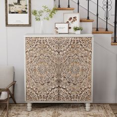 a white cabinet sitting in the middle of a living room next to a stair case