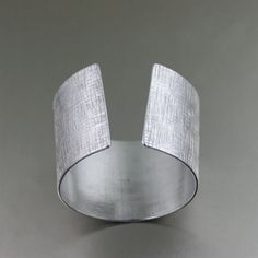 a close up of a metal object on a table with a gray wall in the background