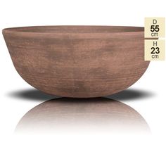 a large wooden bowl sitting on top of a white table next to a measuring tape