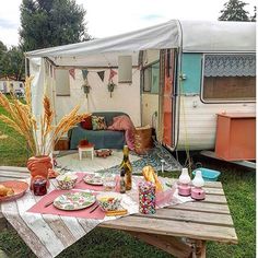 a table with food and drinks on it in front of a camper