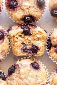 muffins with blueberries and cranberries in them on a white surface