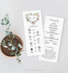 two wedding program cards with greenery on them next to a bowl of flowers and a plant