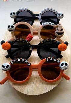 three pairs of sunglasses with faces and words on them sitting on top of a wooden board