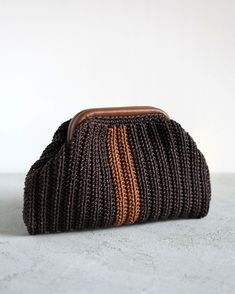 a brown and orange purse sitting on top of a cement floor next to a white wall