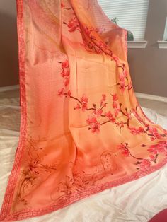 Vibrant and pretty blended satin silk saree in shades of orange. Floral vines is printed on the top portion of the pallu with pebble like prints on the lower part.Pleats will be a bright orange with floral sequins in the bottom part and continues as bright orange towards the end of the saree. Sequin lace borders runs along the saree. Comes with fall, pico and completely stitched blouse. Saree width: 43 inch Blouse details: Back hook with mild puff along the sleeves. chest size: 36 with 3 inch margin waist size: 32 with 3 inch margin Arm hole: 18 inch sleeve length: 11 inch Length: 14 inch Maintenance: Dry wash advisable Returns and refund only accepted on defective products. Product should be shipped back in 3 days after delivery . Please go through our return policies below. Our Policy on Red Silk Saree With Floral Print, Traditional Silk Blouse Piece In Orange, Traditional Drape Orange Silk Blouse Piece, Red Silk Dupatta With Digital Print, Orange Unstitched Katan Silk Blouse Piece, Elegant Silk Printed Dupatta, Orange Silk Saree With Pallu, Festive Peach Silk Dupatta, Elegant Orange Silk Blouse Piece