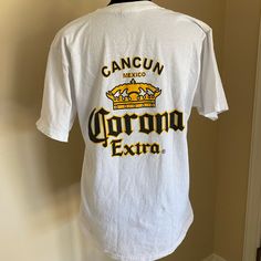 Corona Tee Shirt Size Medium From Cancun Never Worn Excellent Condition Summer Fan Apparel Tops With Logo Print, Summer Logo Print Fan Apparel Tops, Summer Fan Apparel T-shirt With Logo Print, Pre-shrunk White Print Crew Neck Shirt, White Relaxed Fit T-shirt For Fans, White Crew Neck Shirt Fan Apparel, White Cotton Fan Apparel Tops, White Crew Neck Shirt For Fans, White Print Crew Neck Shirt With Logo