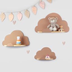 two teddy bears sitting on top of shelves in the shape of clouds with leaves hanging from them