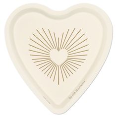 a heart shaped dish with sunbursts on the front and side, in white