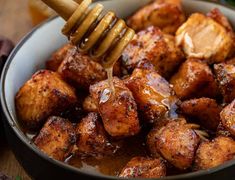 a bowl filled with honey and fried tofu