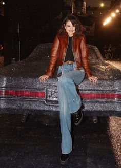 a woman sitting on the hood of a car