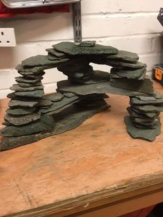 a wooden table topped with lots of rocks and a piece of wood on top of it