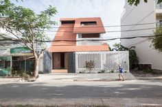 the house is made up of two stories and has an unusual roof that matches with the surrounding buildings