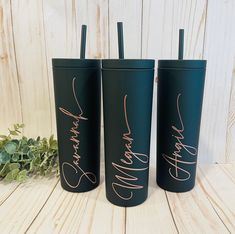 three black tumblers with rose gold lettering on them and one has a straw in it