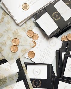 many different types of wedding cards and envelopes with gold buttons on them, all in black and white