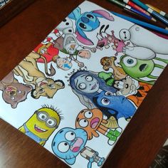 an image of cartoon characters on a notebook with colored pencils next to it and another drawing in the background