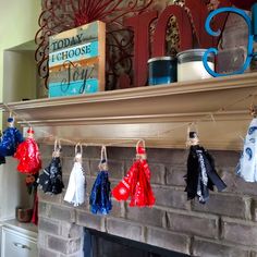 the mantle is decorated with red, white and blue scarves hanging from it's hooks