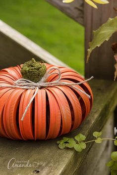 an orange pumpkin sitting on top of a wooden bench