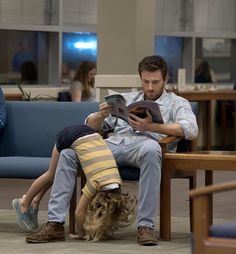 a man sitting on a chair next to a woman reading