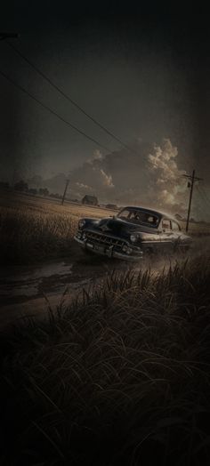 an old car driving down a road in the middle of a cornfield at night